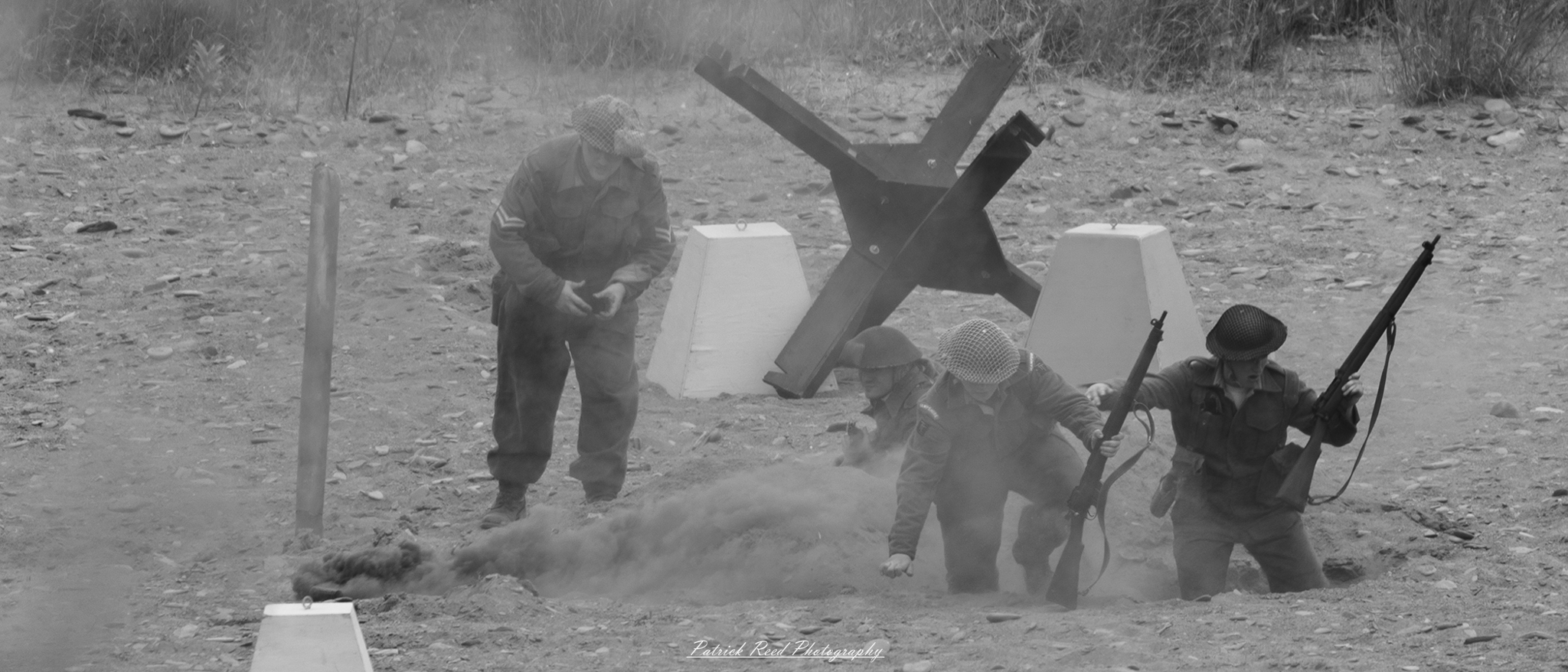 A gripping scene of two soldiers in a blast crater, surrounded by debris and dust. The image conveys the raw reality of combat, highlighting the soldier's resilience and focus in a chaotic environment.